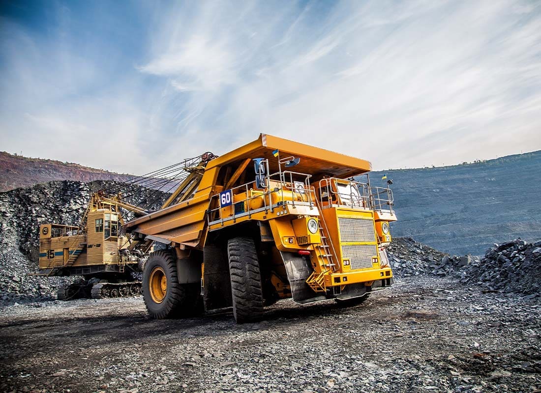 Mining Insurance - Landscape View of Mines and a Loaded Mining Truck Transporting Platinum Ore at Dusk