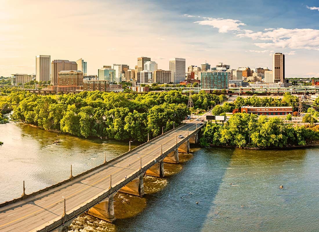 Contact - Aerial View of a Bridge Leading to Downtown Richmond Virginia with Green Trees and Commercial Buildings on a Sunny Day