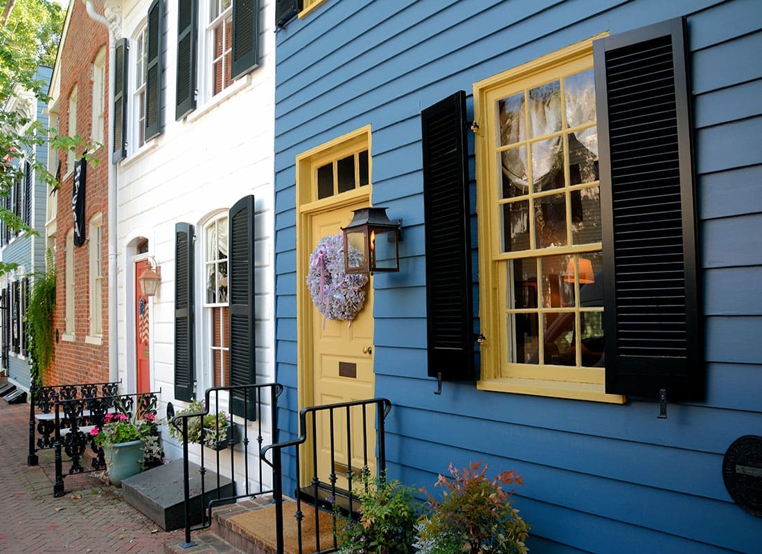 Insurance Solutions - Closeup View of Row of Colorful Colonial Homes in Old Town Alexandria Virginia with Lanterns and Wreaths Hanging by the Front Doors