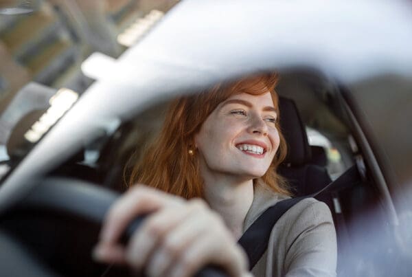Cheap Car Insurance Maryland - Woman Driving Car and Smiling Close Up of Steering Wheel